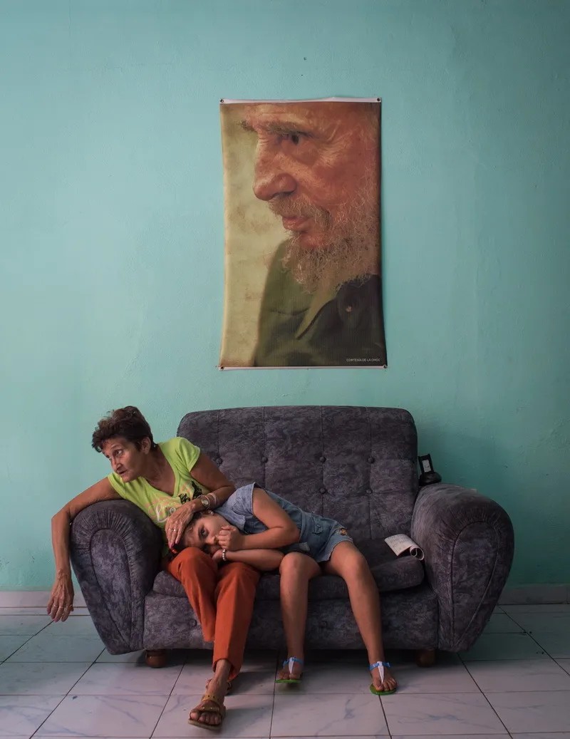 2 декабря 2016 года. Женщина с девочкой сидят на диване в полицейском участке в кубинском городе Камагуэй, через неделю после смерти Фиделя Кастро. Фото: Кристина Кормилицына