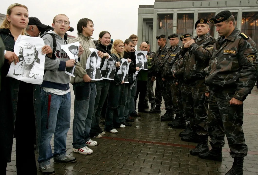Протестующие держат портреты исчезнувших оппозиционеров на митинге в Белоруссии. Фото: Reuters