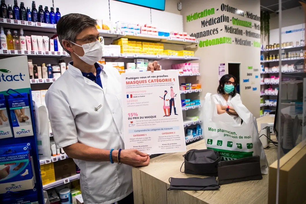 Фармацевт показывает инструкцию по обращению с новыми многоразовыми масками. Фото: EPA