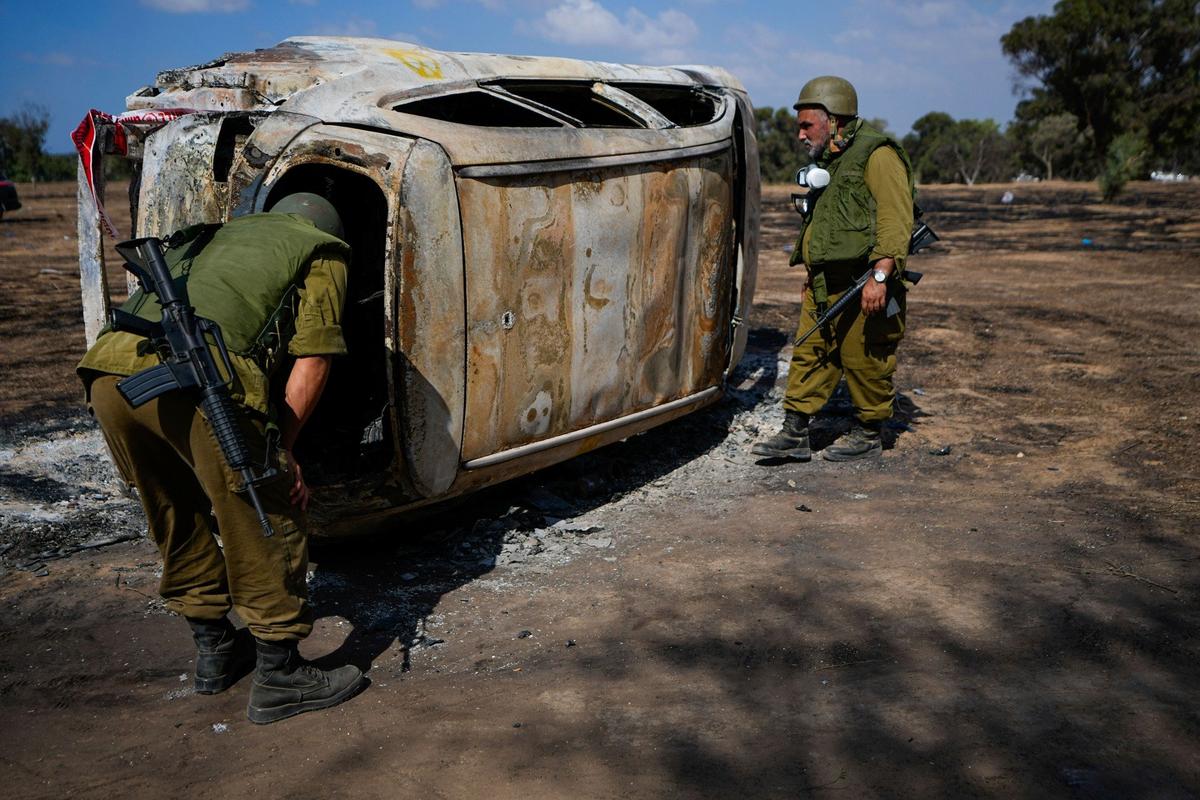 Кибуце Реим. Израильские солдаты осматривают место трагедии. Фото: AP / TASS