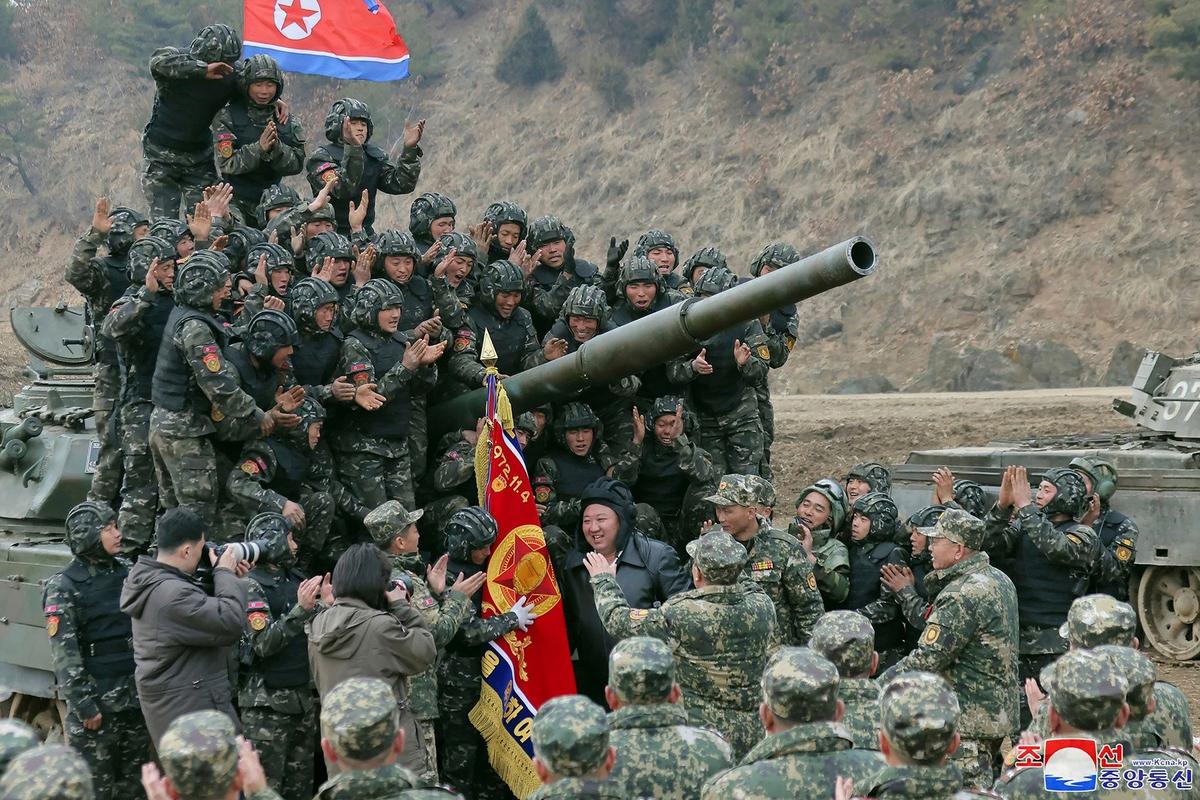 Лидер Северной Кореи Ким Чен Ын (в центре) на учениях танковых экипажей, в ходе которых были продемонстрированы танки нового типа, 14 марта 2024 года. Фото: AP / TASS