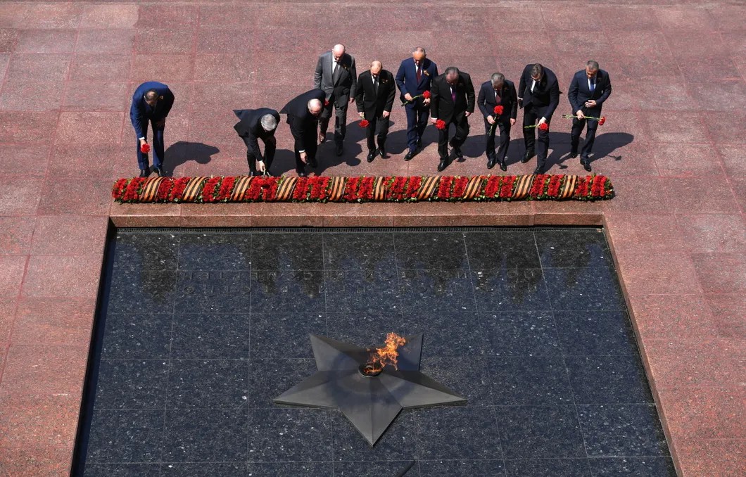 Приехавшие на парад лидеры стран возлагают цветы к Вечному огню. Фото: Reuters