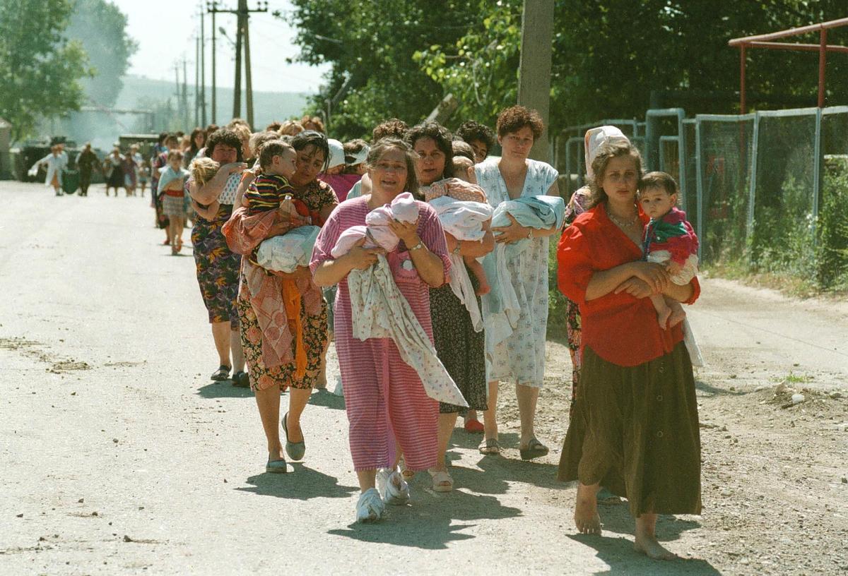 Освобожденные российские заложники, в основном женщины и дети, покидают в сопровождении военных больницу, где они удерживались чеченскими террористами Шамиля Басаева. Фото: Эдди Опп / Коммерсантъ