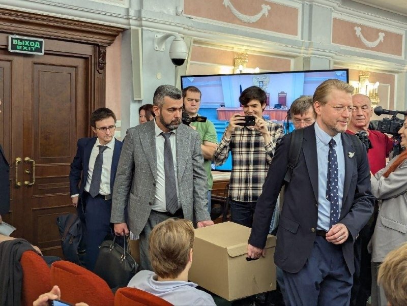 Председатель «Яблока» Николай Рыбаков и защитники партии Гаджи Алиев и Виталий Исаков принесли в суд коробку доказательств. Фото: пресс-служба «Яблока»