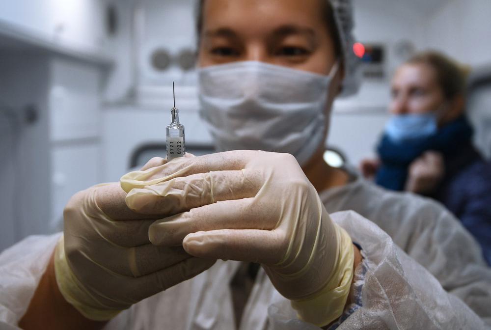 Медик делает прививку с вакциной против гриппа в мобильном пункте вакцинации. Фото: РИА Новости