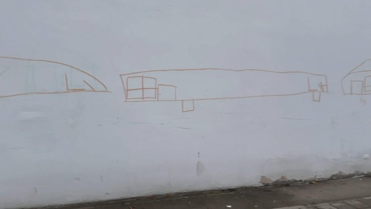 Детские рисунки на стене парка, за которой мемориал