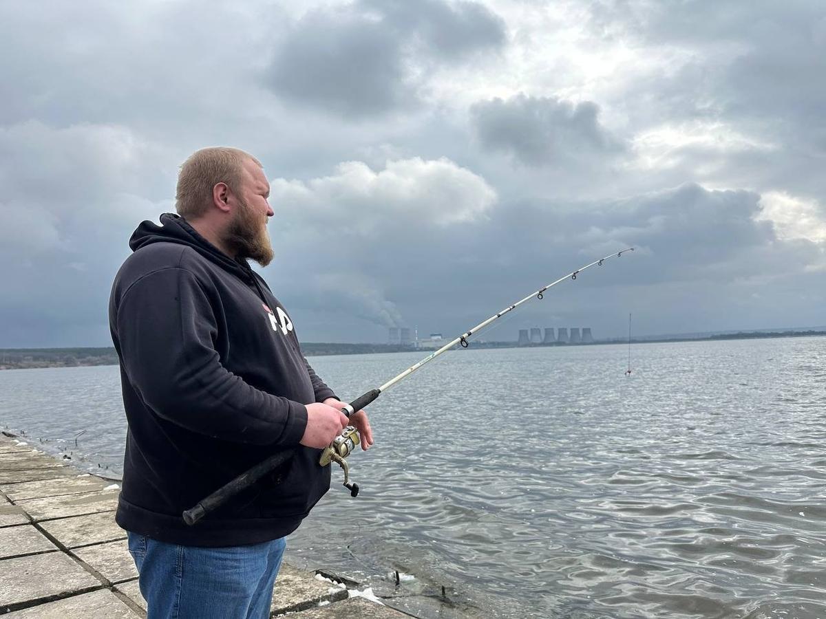 Рыбак Женя, который ловит тиляпию в пруду-охладителе. Фото: Валерия Федоренко / «Новая газета»