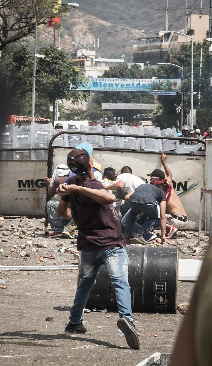Протествующие кидают камни в полицию. Мост Симона Боливара между Колумбией и Венесуэлой. Фото: Родольфо Чурион
