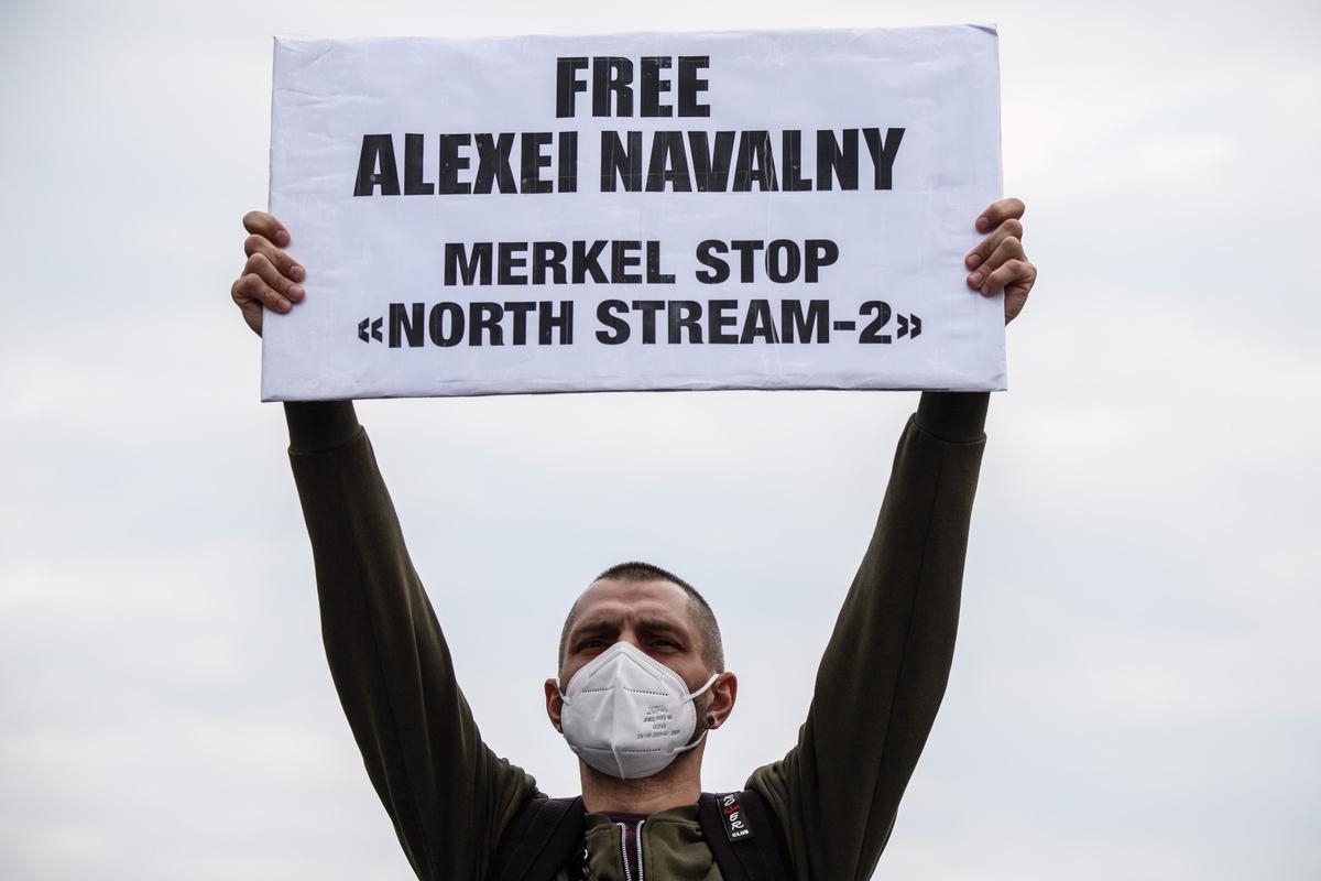 Протестующий с плакатом: «Свободу Алексею Навальному» и «Меркель, останови "Северный поток-2"». Фото: EPA-EFE