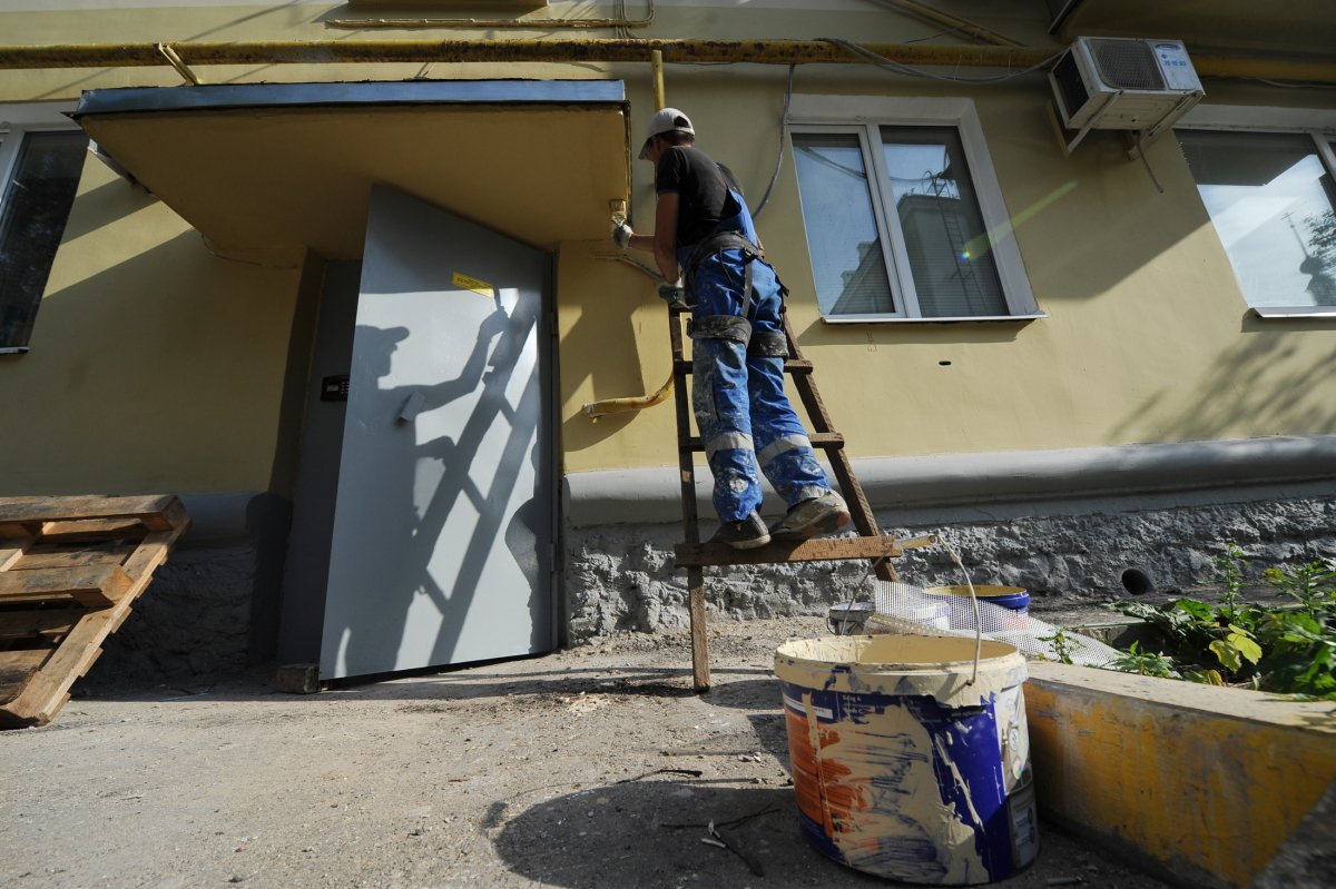 Работы по капитальному ремонту фасада дома. Фото: Александр Рюмин / ТАСС