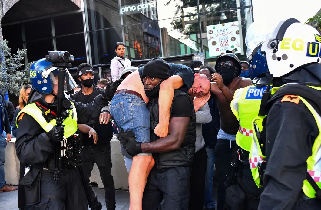 Чернокожий протестующий Патрик Хатчинсон выносит наци-скинхеда из толпы, пытаясь не дать демонстрантам забить расиста. Фото: Reuters