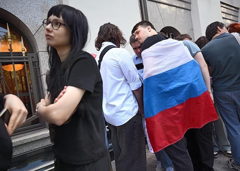 Молодые люди у здания Верховного суда, где рассматривался иск о снятии партии «Яблоко» с выборов. Фото: Ирина Бужор / Коммерсантъ