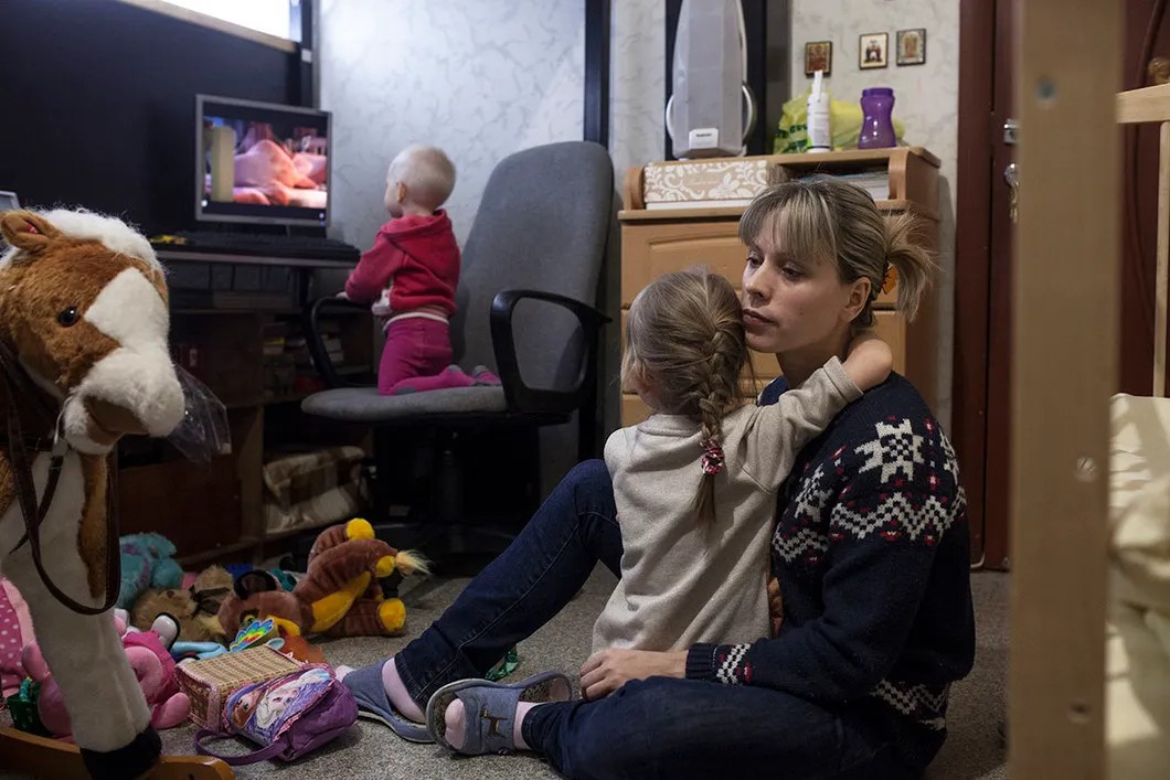 Анна с дочками. Их семья из четырех человек живет в одной комнате в 13 кв.м. Фото: Влад Докшин / «Новая газета»
