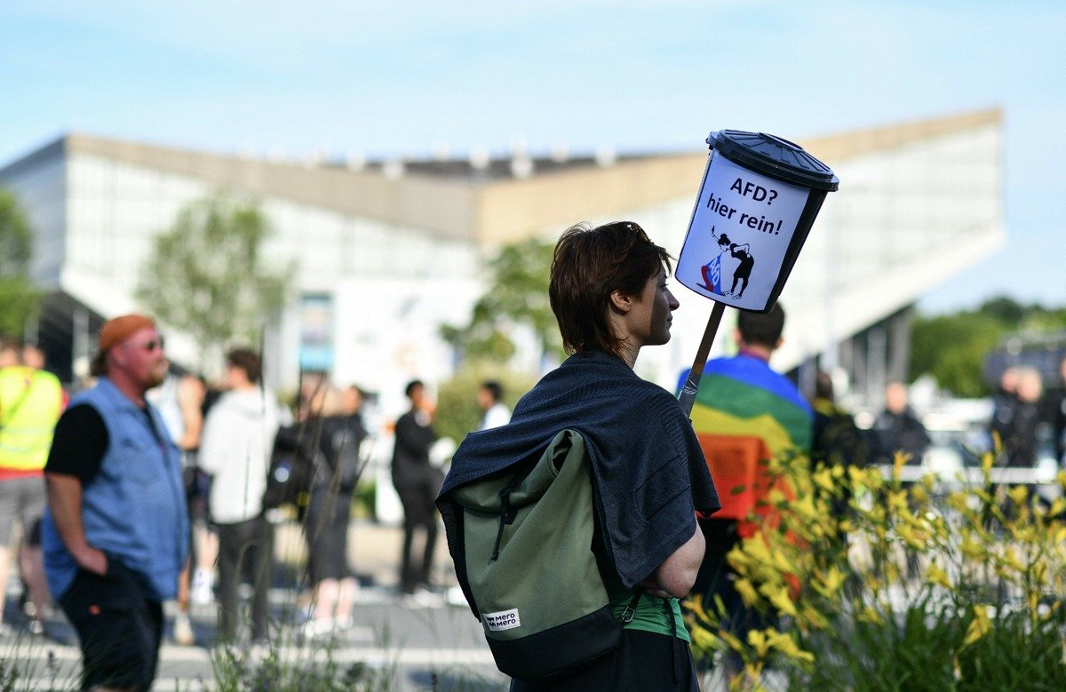 Протестующий держит мусорный бак с надписью «AfD? Сюда!», во время акции против партии «Альтернатива для Германии», Эссен. Фото: VOLKER HARTMANN / AFP / East News