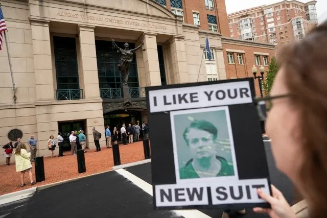 «Мне нравится твой новый костюм» — говорится на плакате с Полом Манафортом в тюремной робе. Пикет у зала суда. Фото: Reuters