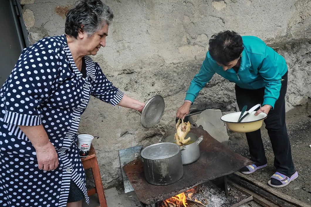 В одном из дворов. Люди, живущие в подвалах домов готовят обед. Фото: Павел Волков / специально для «Новой»