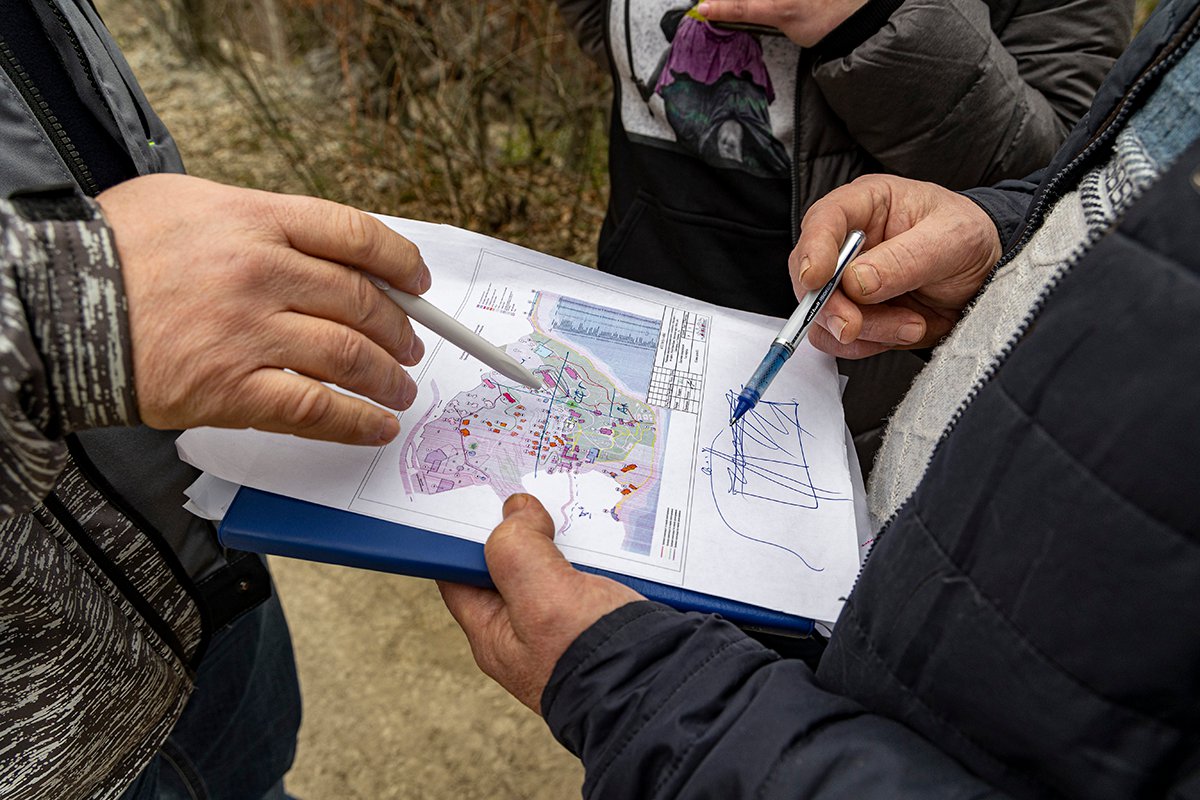 Представители подрядчика показывают план застройки Меласского парка. Фото: Арден Аркман / «Новая»
