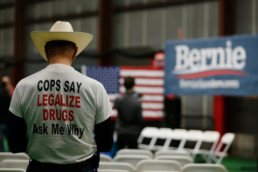 Потенциальный избиратель Берни Сандерса в футболке «Копы за легализацию наркотиков. Спроси меня, почему». Фото: EPA