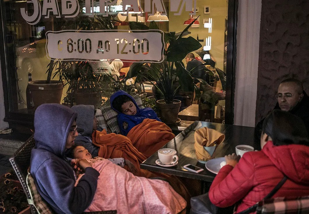Иностранные болельщики спят на веранде питерского кафе. Фото: Влад Докшин / «Новая газета»
