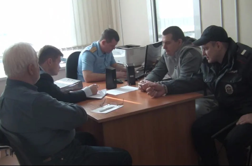 Бывший сотрудник ГУЭБиПК МВД (второй справа) Виталий Чередниченко на допросе в СКР