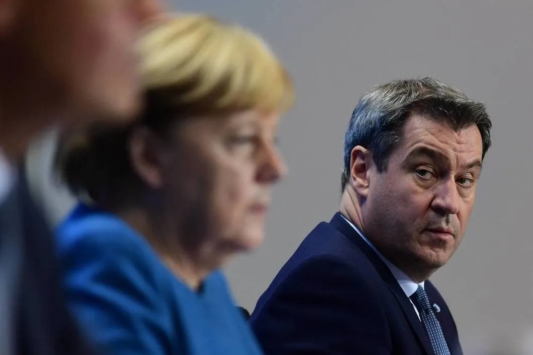 Лидер Христианско-социального союза в Баварии Маркус Зёдер рядом с Ангелой Меркель после пресс-конференции о ситуации с коронавирусом в Германии, октябрь 2020 года. Фото: Pool / Getty Images