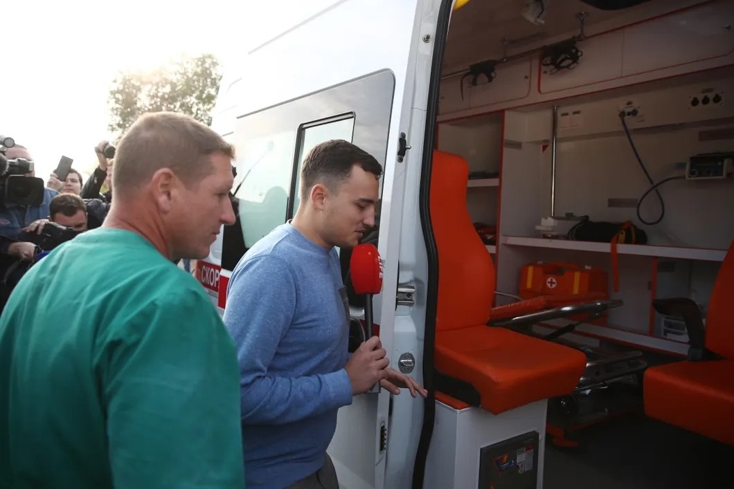 Корреспондент Life News Виталий Молев (справа) перед осмотром сотрудником скорой помощи. Фото: Сергей Бобылев/ТАСС