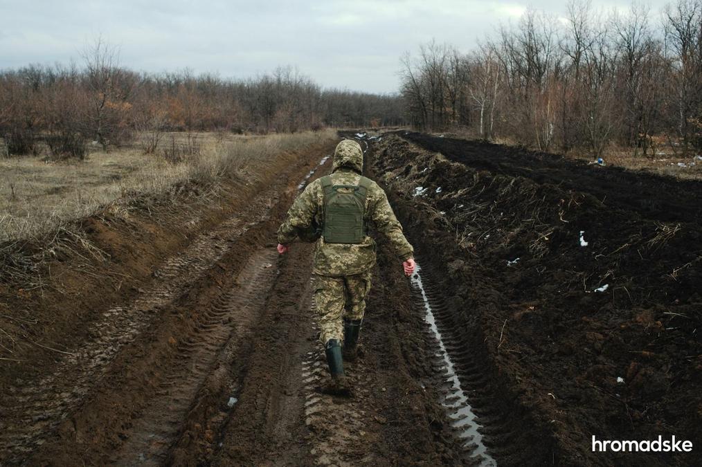Военный показывает путь к селу Новоалександровка по грунтовой дороге, на которой обычный транспорт не сможет проехать. Фото: Макс Левин / hromadske