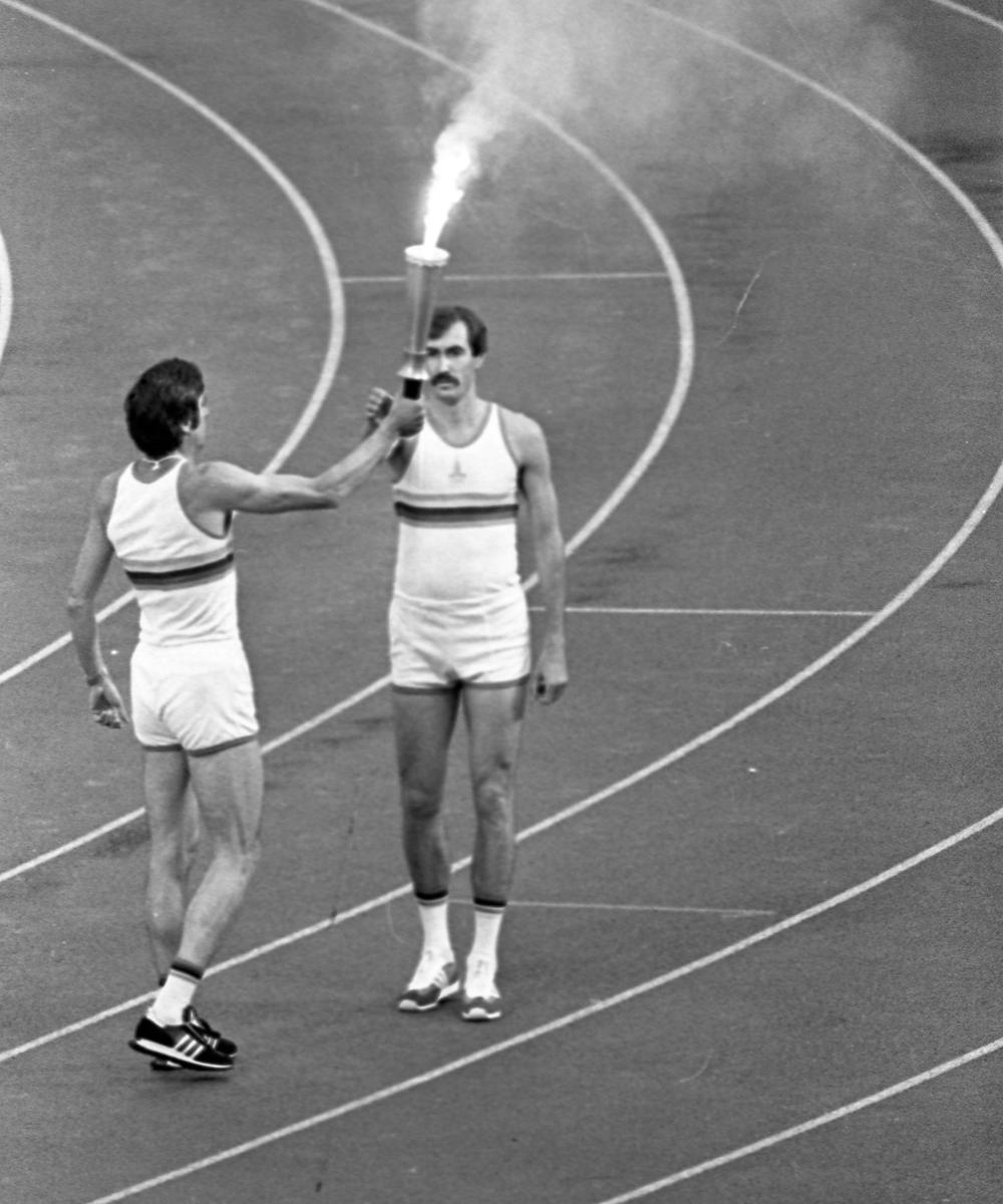 19 июля 1980 года. Москва. Центральный стадион имени Ленина. Открытие XXII летних Олимпийских игр. Трехкратный олимпийский чемпион в тройном прыжке Виктор Санеев передает факел баскетболисту Сергею Белову. Фото: Евгений Успенский