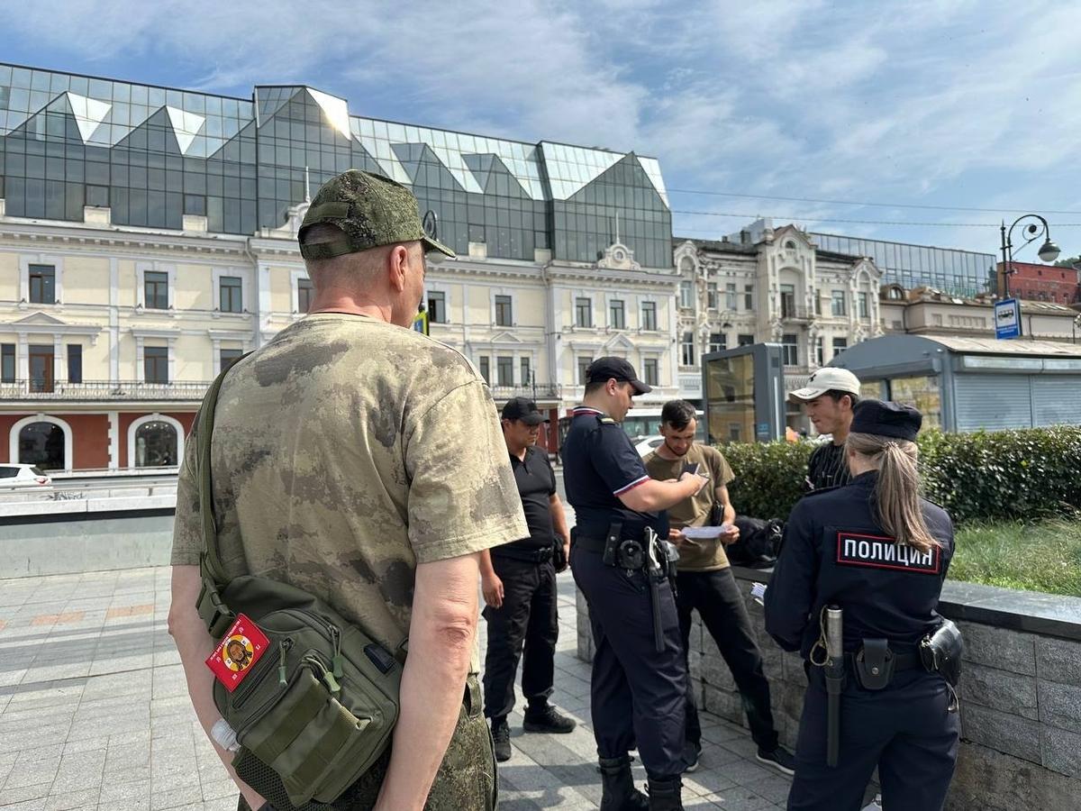 Патрульные и дружинники проверяют документы у группы мигрантов. Фото: Валерия Федоренко / «Новая газета»