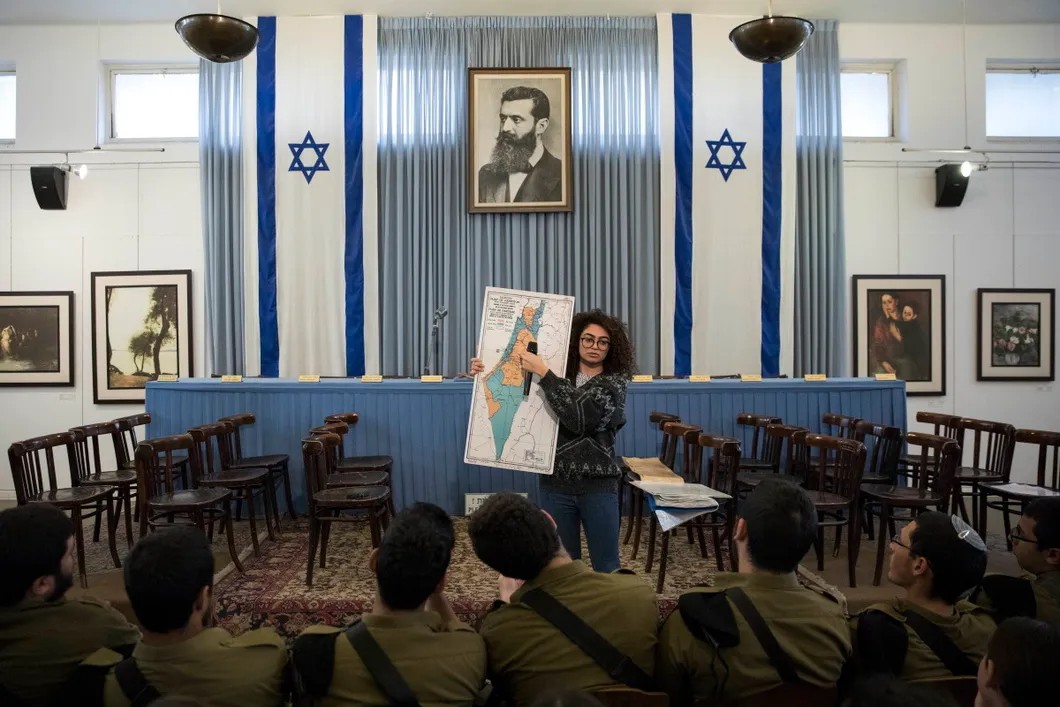 Израильский инструктор рассказывает солдатам о плане раздела раздела Израиля и Палестины от 1948 года в зале независимости, где Давид Бен-Гурион провозгласил создание еврейского государства. Фото: EPA