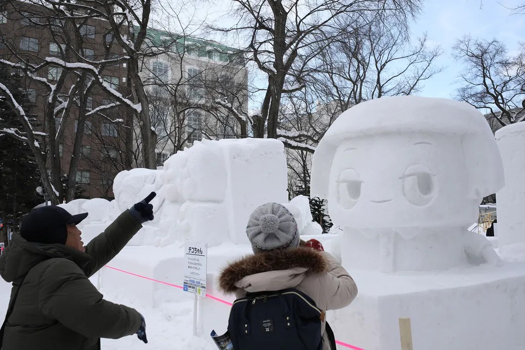 Японцы фотографируются около снежных статуй. Фото: Анна Артемьева / «Новая газета»