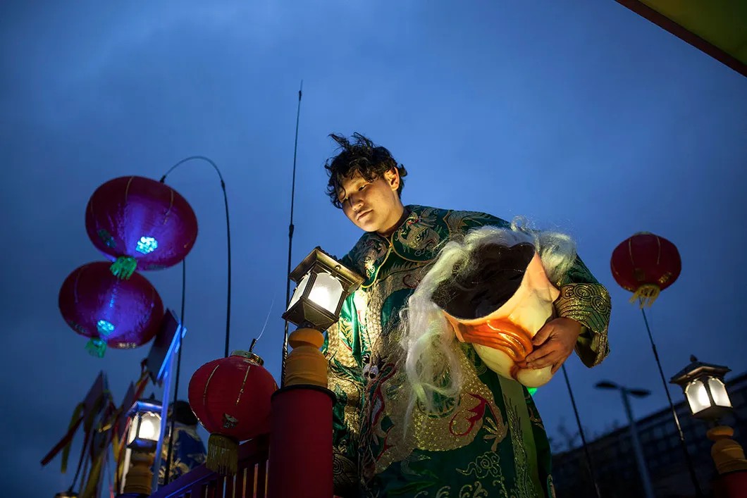 Бурятский актер снимает китайский народный костюм после окончания шествия. Фото: Влад Докшин / «Новая газета»