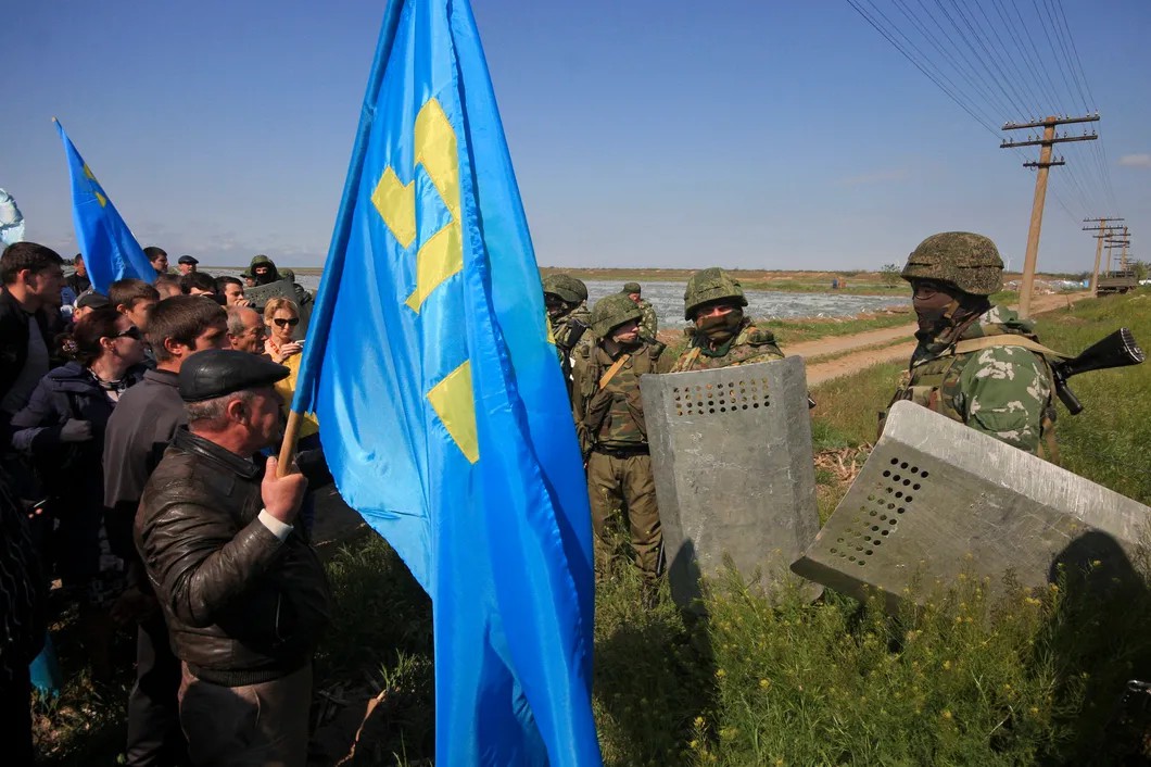 Российские военнослужащие пытаются заблокировать путь для крымских татар, пересекающих контрольно-пропускной пункт, соединяющий Крым и Херсонскую область. Май 2014 года. Фото: Reuters