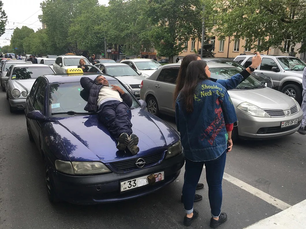 Таксисты тоже присоединились к акциям протеста. Николай лежит на капоте своей машины. Фото: Илья Азар / «Новая газета»