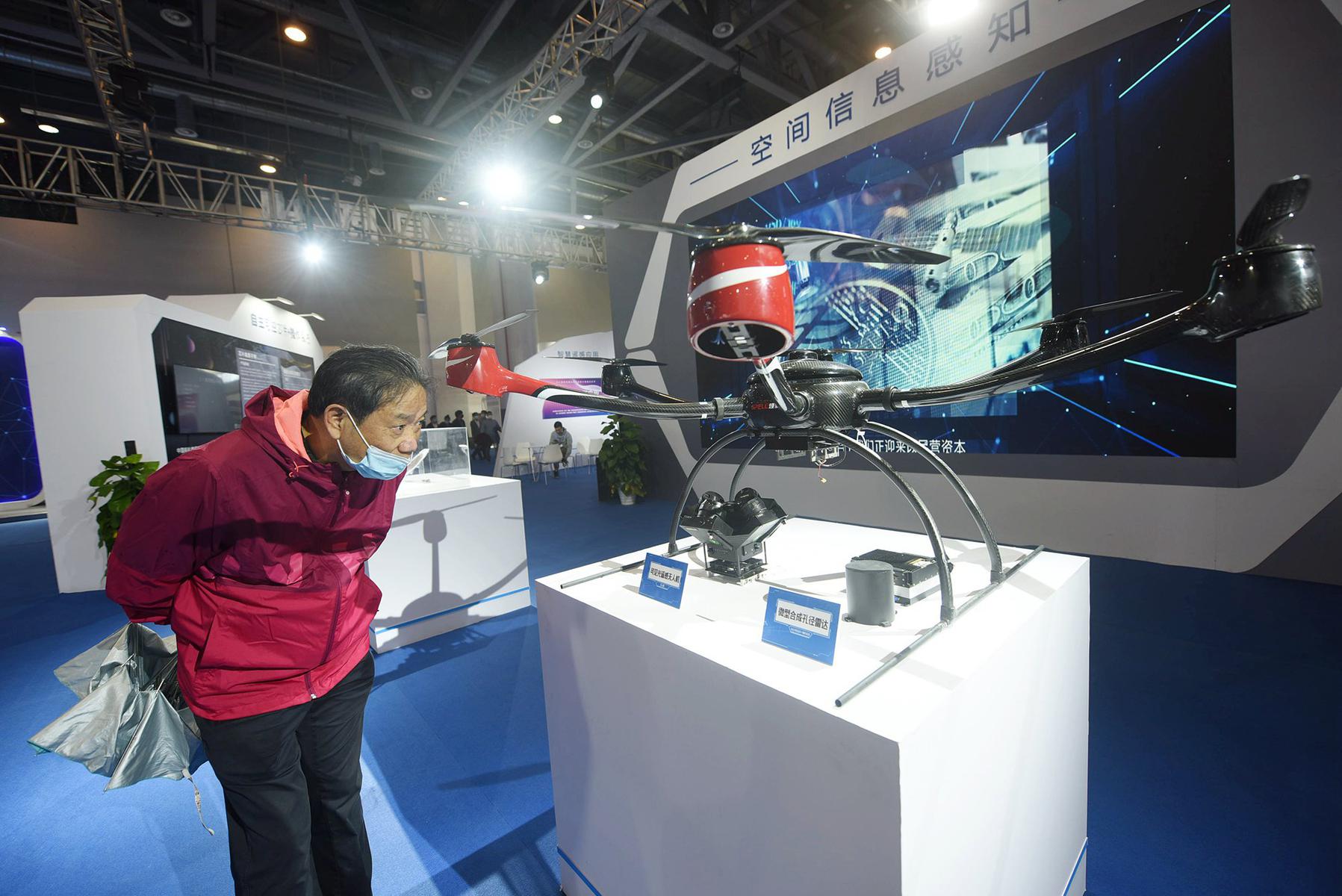 Посетитель рассматривает беспиолотный летательный аппарат на технологической выставке в Гуанчжоу (Китай). Фото: Getty Images