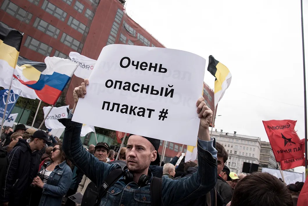 Участник акции напоминает о том, что полиция может задерживать за надпись на плакатах. Фото: Виктория Одиссонова / «Новая»