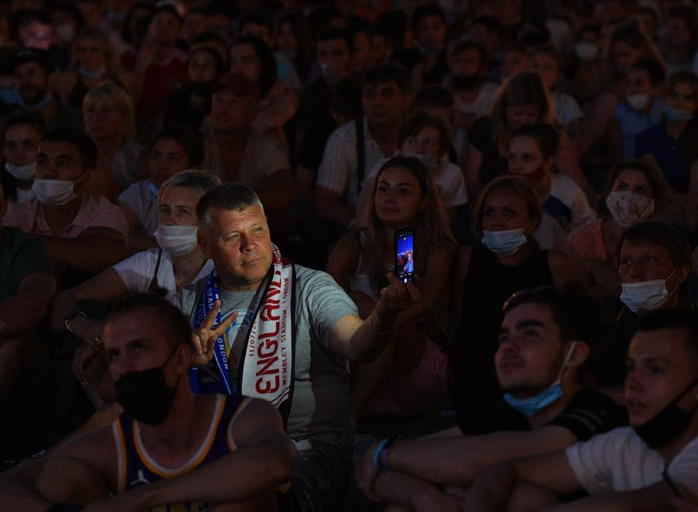 Болельщики смотрят трансляцию матча финала чемпионата Европы по футболу 2020 на Дворцовой площади в Санкт-Петербурге, 11 июля 2021 года. Фото: РИА Новости