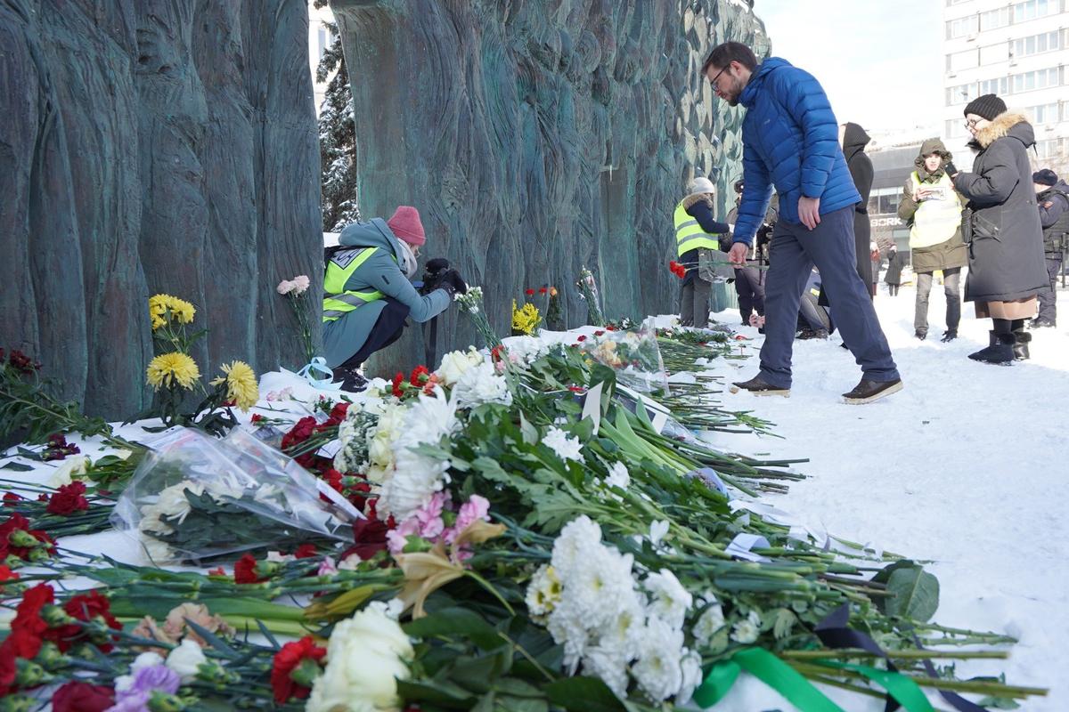 Люди несут цветы к «Стене скорби» в память об Алексее Навальном. Фото: Анастасия Цицинова / «Новая газета»