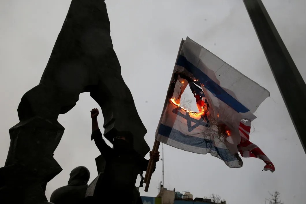 Иранцы сжигают флаги США и Израиля на похоронах генерала Касема Сулеймани. Фото: Reuters
