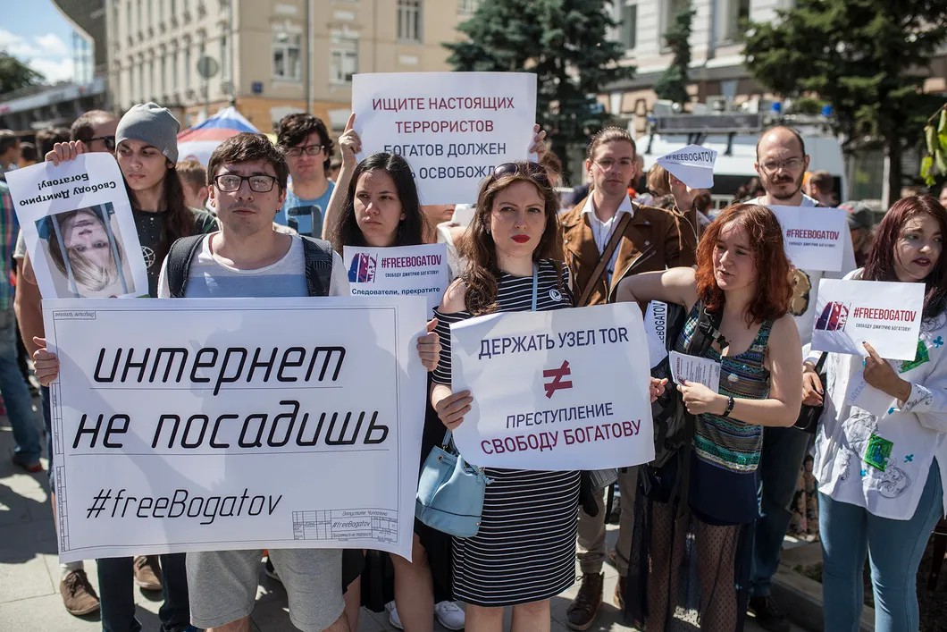 Участники шествия держат плакаты в поддержку арестованного математика Дмитрия Богатова. Фото: Влад Докшин / «Новая газета»