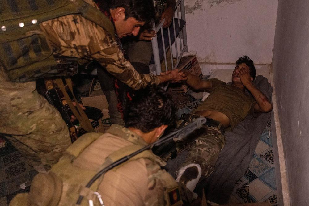 Бойцы афганского спецназа помогают солдату национальной армии, раненному во время перестрелки с талибами. Фото: Reuters