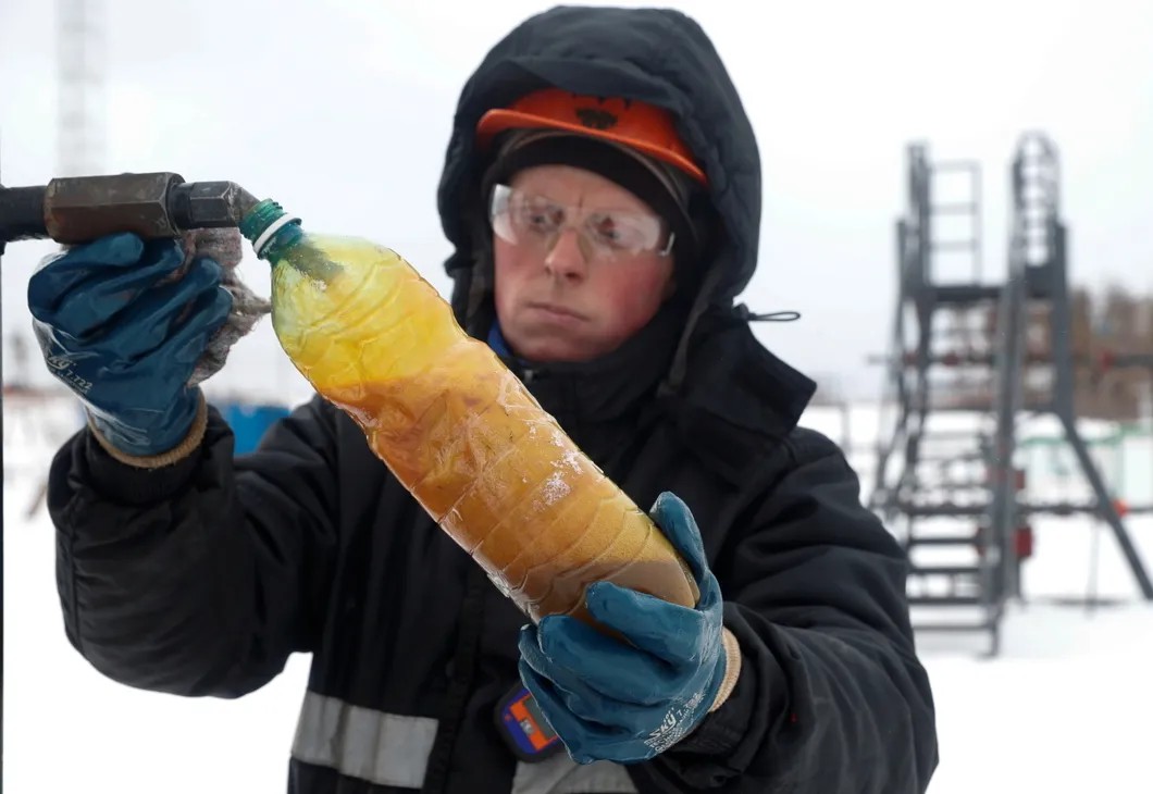 Месторождение нефти в Иркутской области. Специалист берет пробу. Фото: Reuters