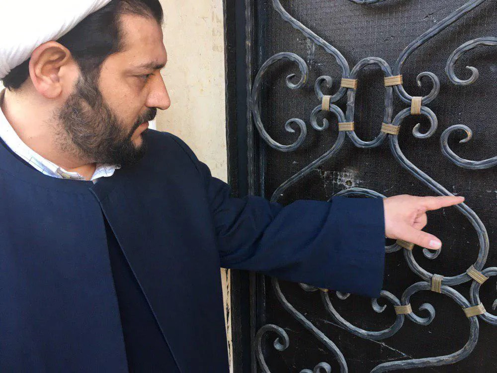 Шейх Аббес Аль-Джаухари показывает нам свежие следы от пуль на воротах своего дома. Фото: Вадих Эль-Хайек / специально для «Новой»