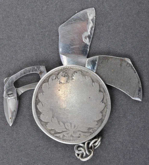 Монета с набором ножа, пилочки и ножниц внутри. Фото: Bournemouth News