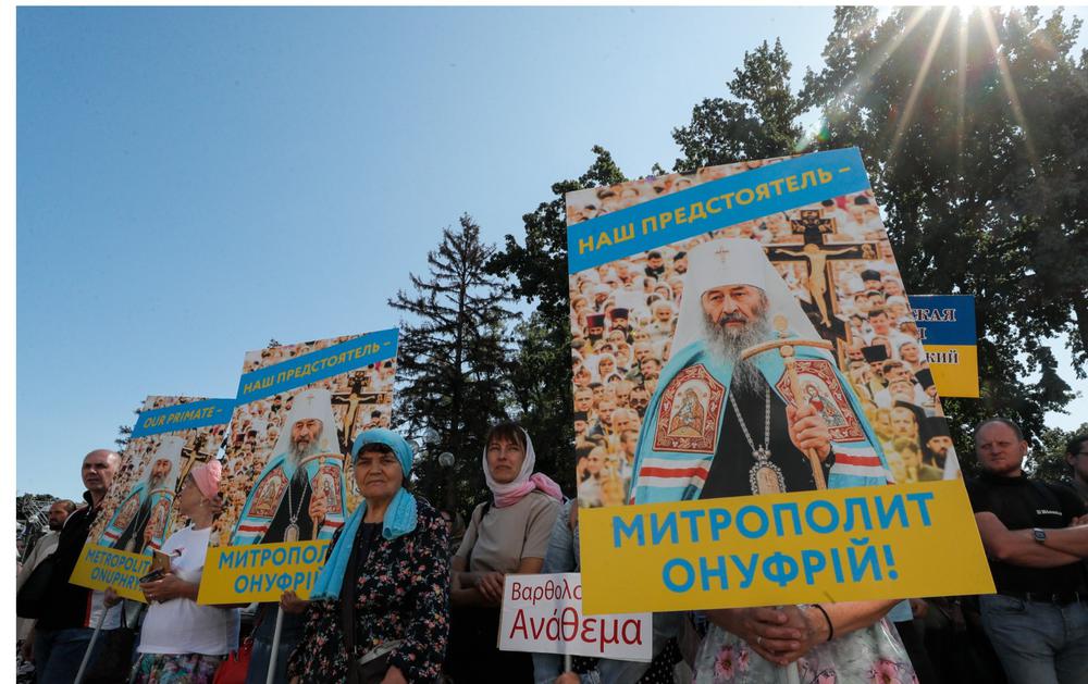 Прихожане УПЦ МП держат плакаты с портретами Митрополита Онуфрия перед зданием Верховной рады, 21 августа. Фото: ЕРА