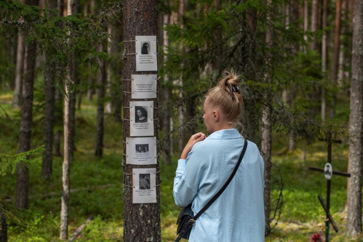Посетительница урочища Сандормох у фотографий с жертвами репрессий. Фото: Алексей Душутин / «Новая газета»