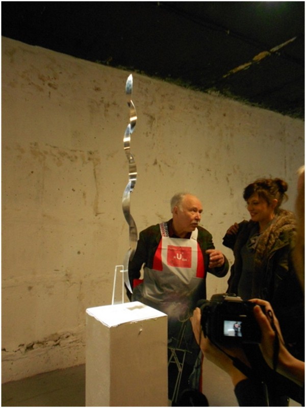 Вячеслав Колейчук на выставке в Строгановке объясняет, как «опровергает» закон всемирного тяготения его стоящая нить. Фото: Ким Смирнов/ «Новая»