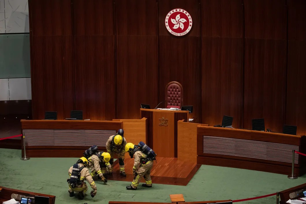 Пожарные проверяют трибуну заксобрания после того, как оппозиционный депутат бросил в сторону кафедры неизвестный предмет. Фото: EPA