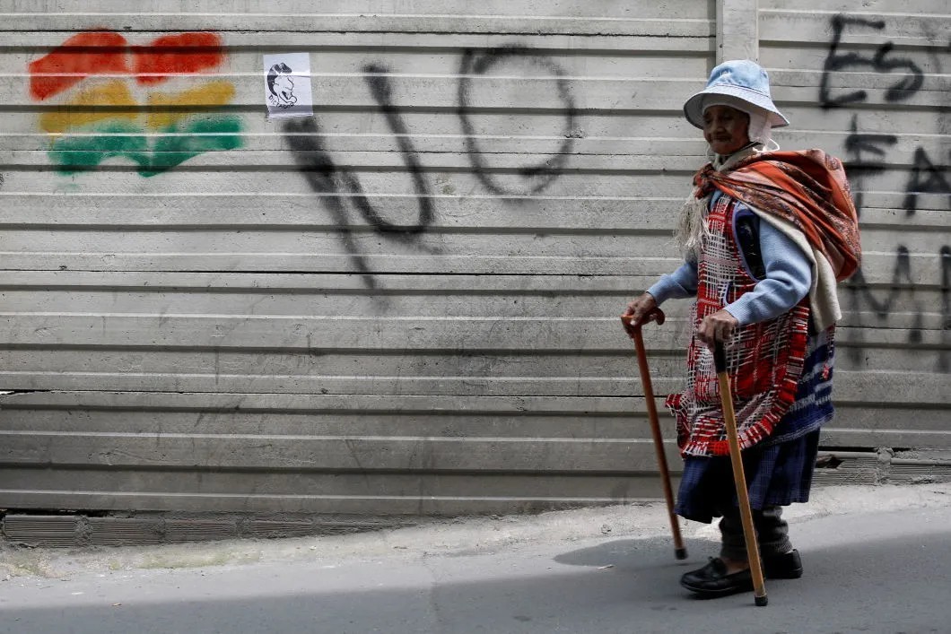 Боливийская индианка на фоне забора в Ла Пасе. Фото: Reuters
