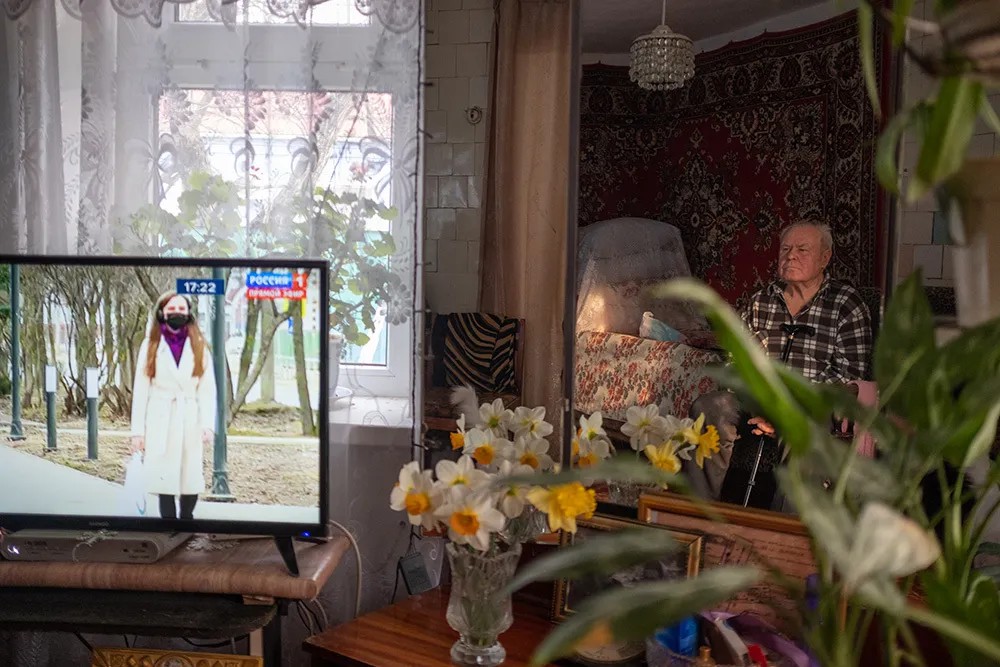 Пожилой мужчина смотрит телевизор у себя дома во время самоизоляции. Фото: Николай Хижняк / РИА Новости